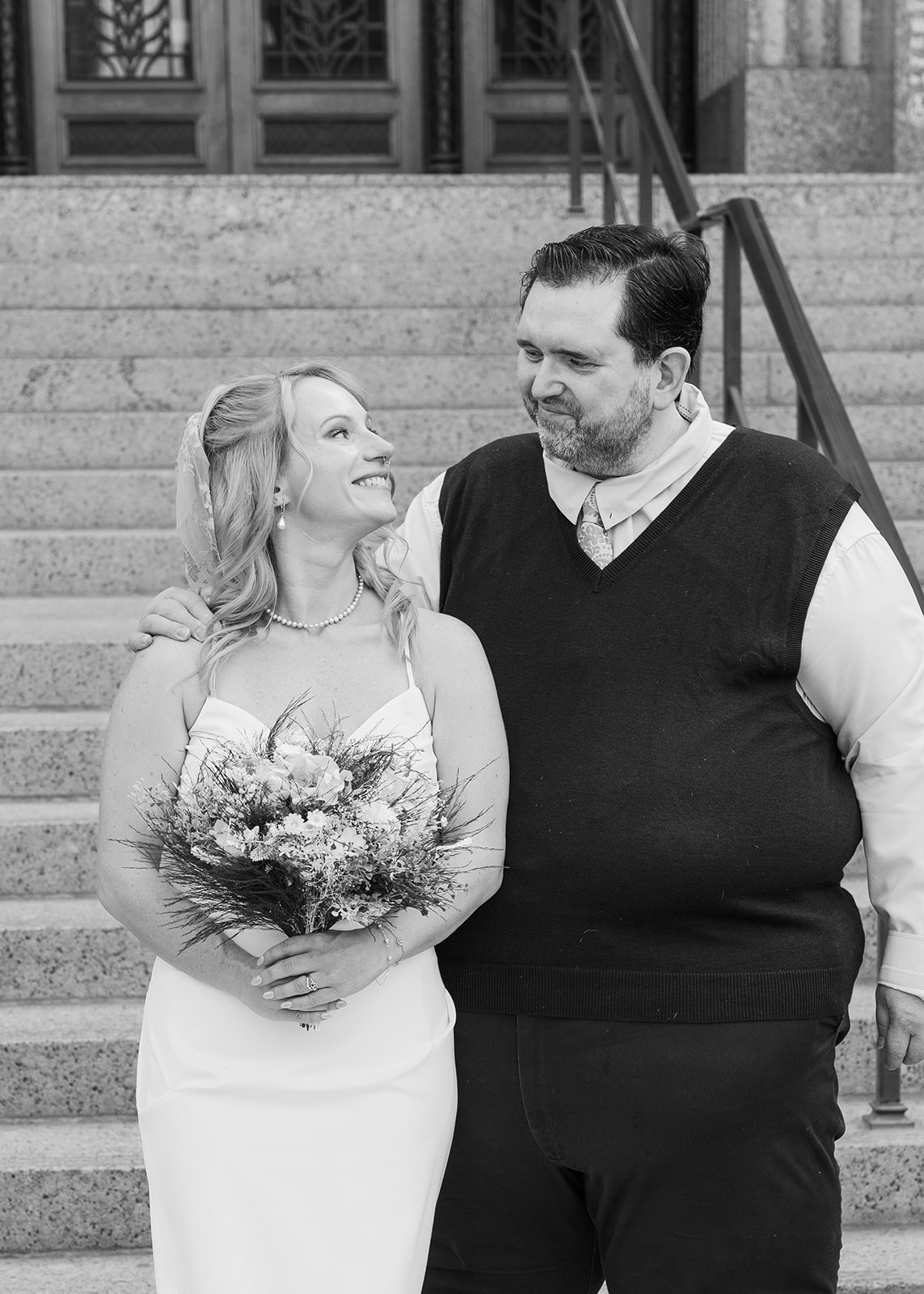 Bride smiling with her family in colorful outfits on the steps of Phoenix City Hall after their Phoenix Courthouse Wedding