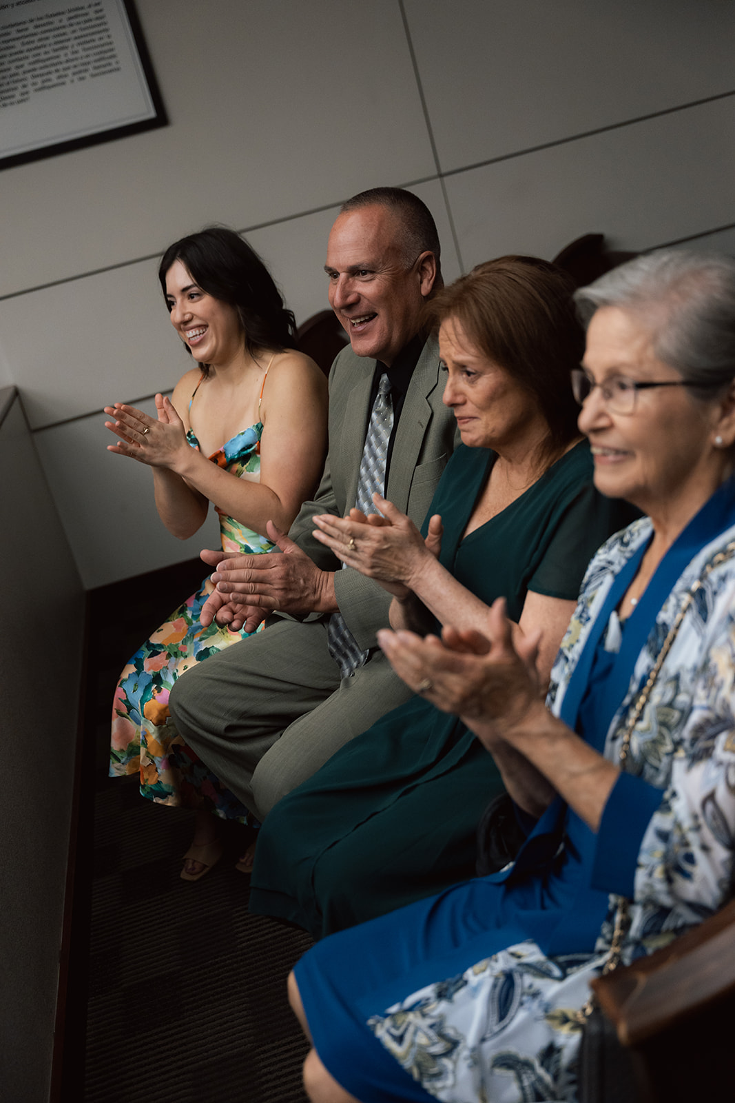 Family members sitting and clapping during an intimate courthouse wedding ceremony