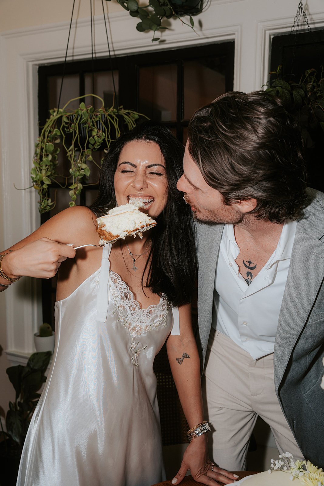 Bride laughing while eating cake with groom during their Phoenix Courthouse Wedding celebration