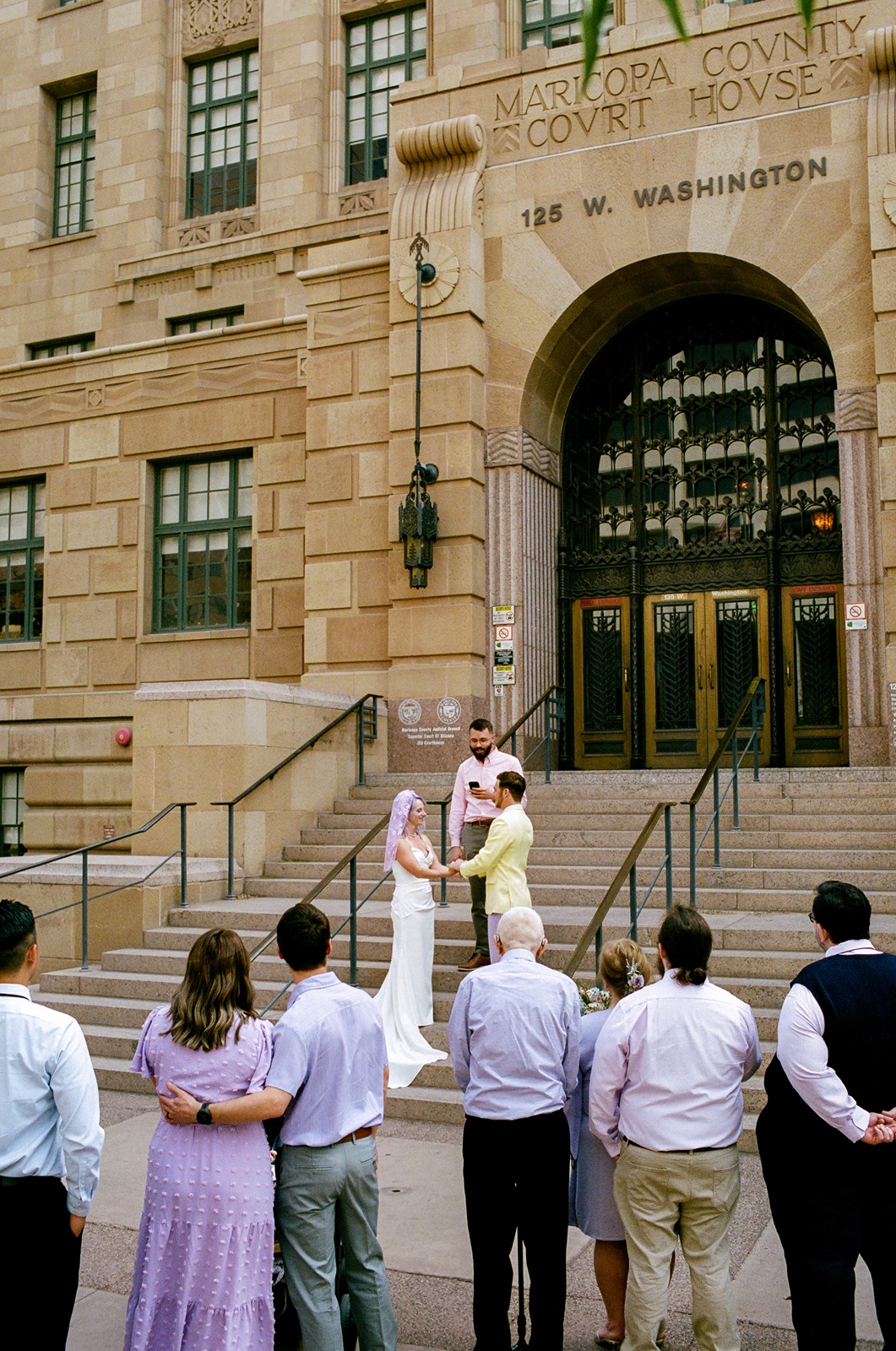 Couple embracing on steps during outdoor vows at their Phoenix Courthouse wedding