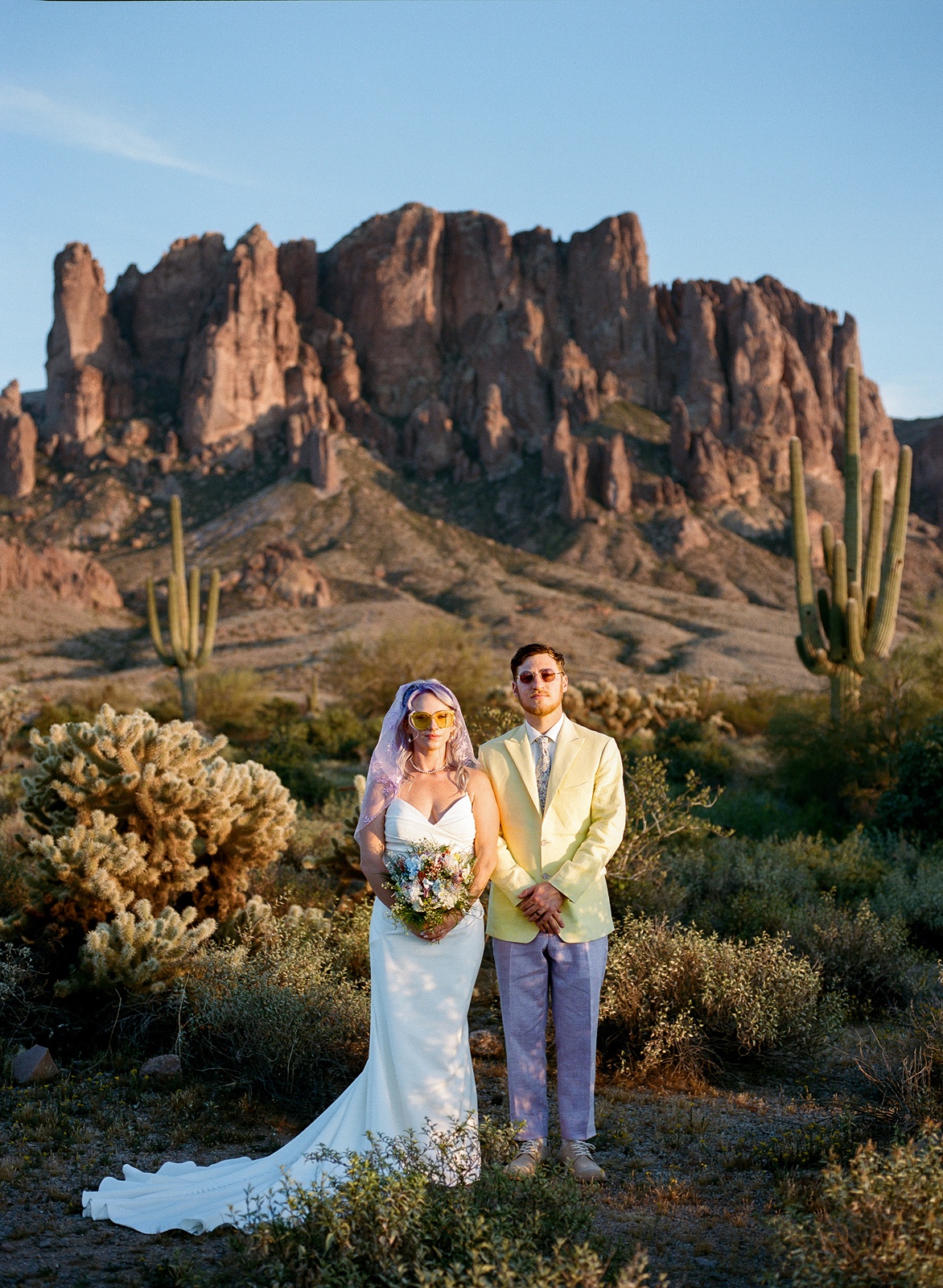 Bride and groom look directly at camera at Lost Dutchman State Park