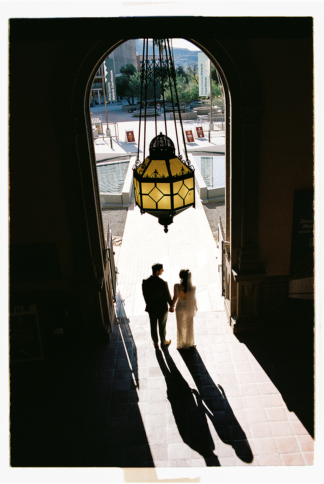 Silhouetted couple standing beneath ornate hanging lantern