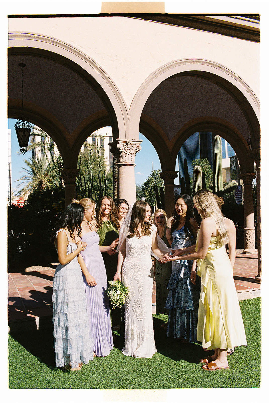 Non-traditional wedding group celebrating under arched courtyard