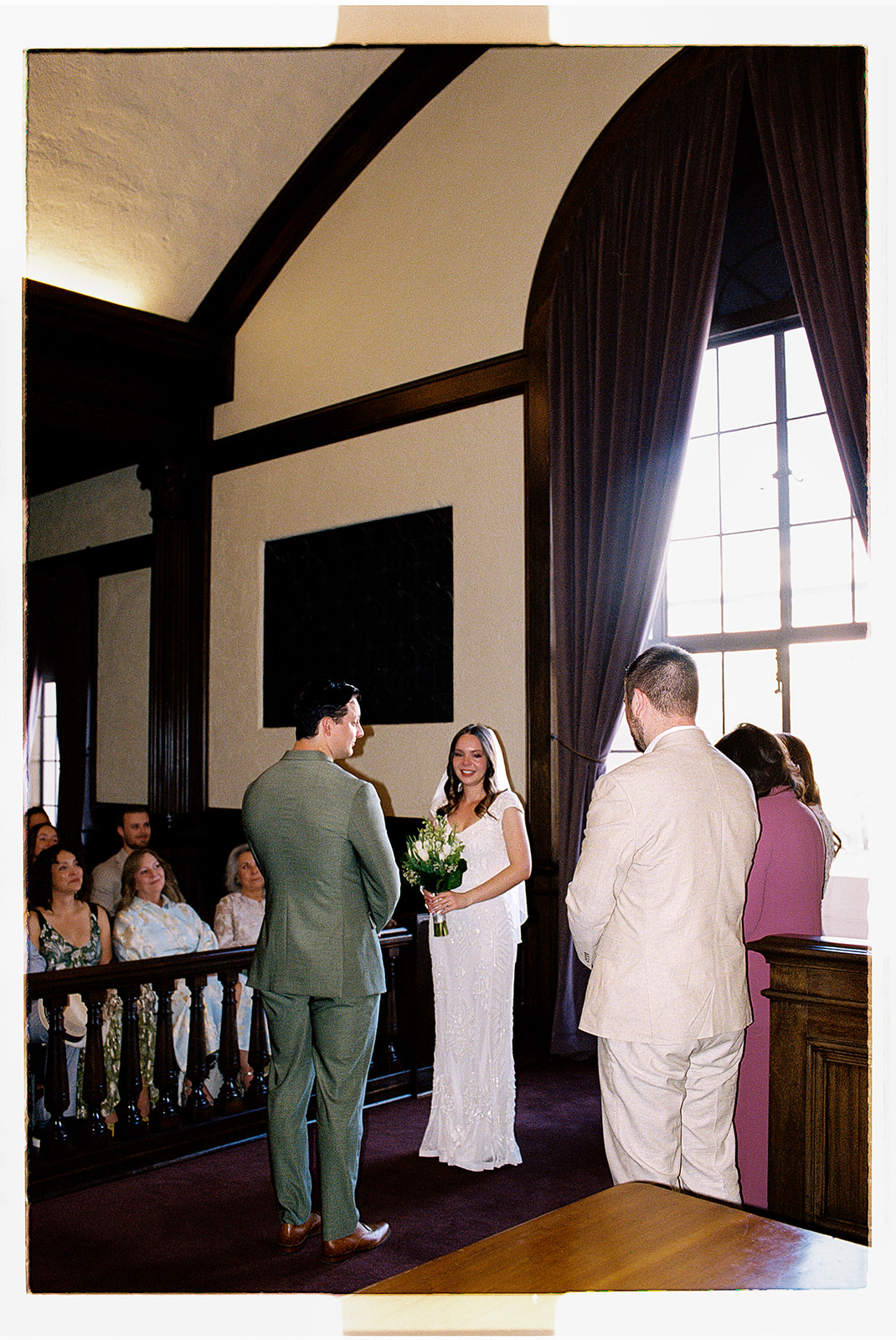 Non-traditional wedding ceremony indoors with guests gathered