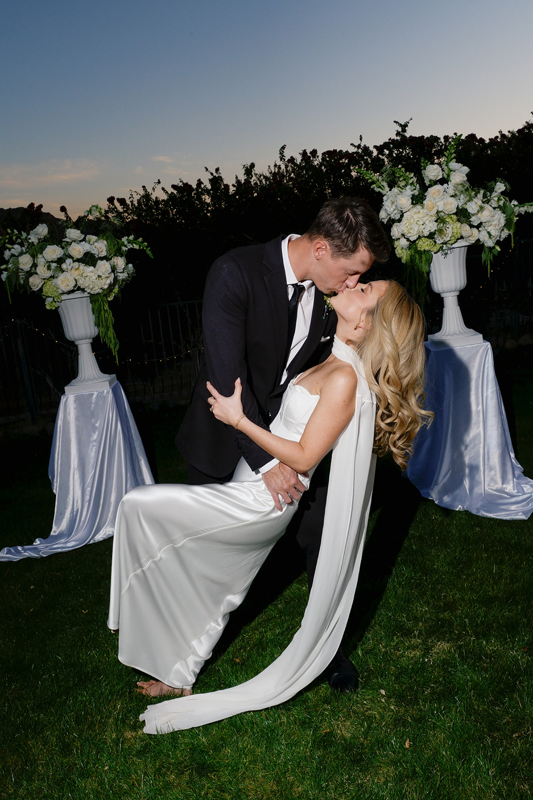 Bride and groom kiss at dusk at their non-traditional wedding