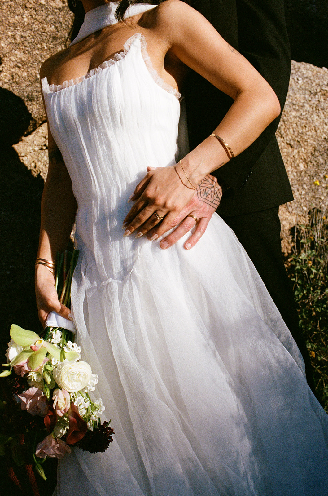 Close up of bride's wedding dress details and bouquet