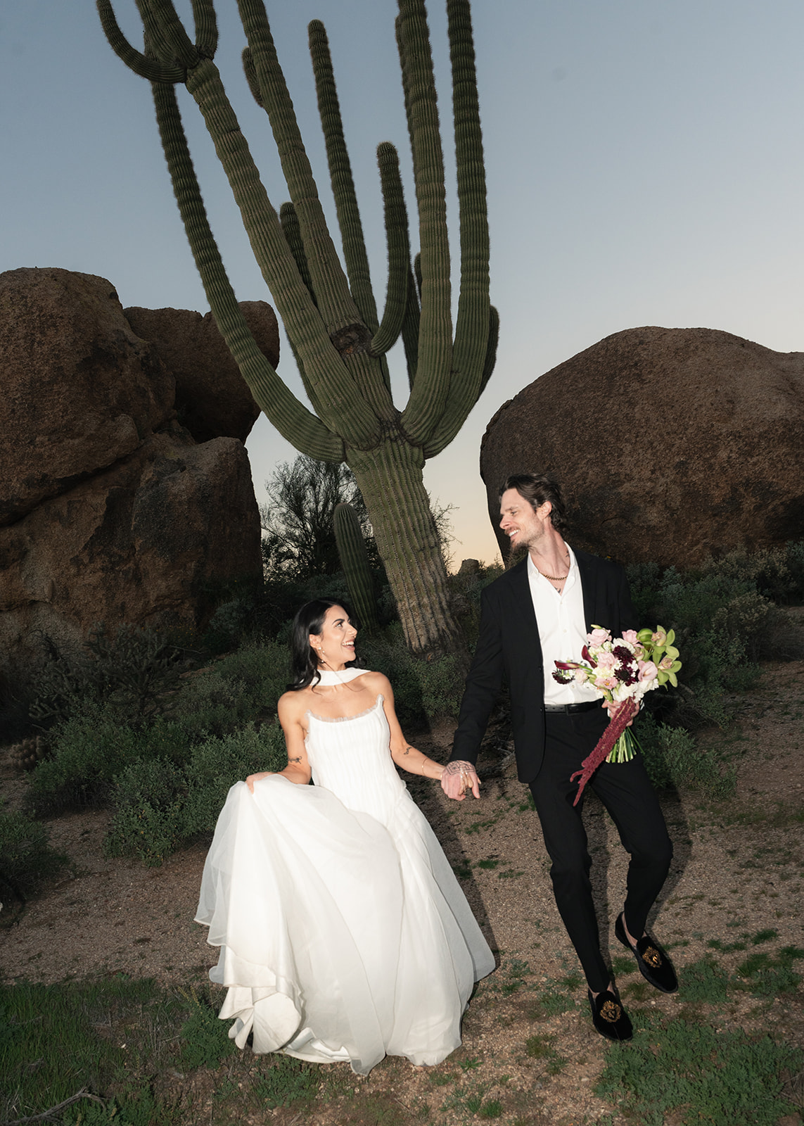Bride and groom hold hands in the Arizona desert