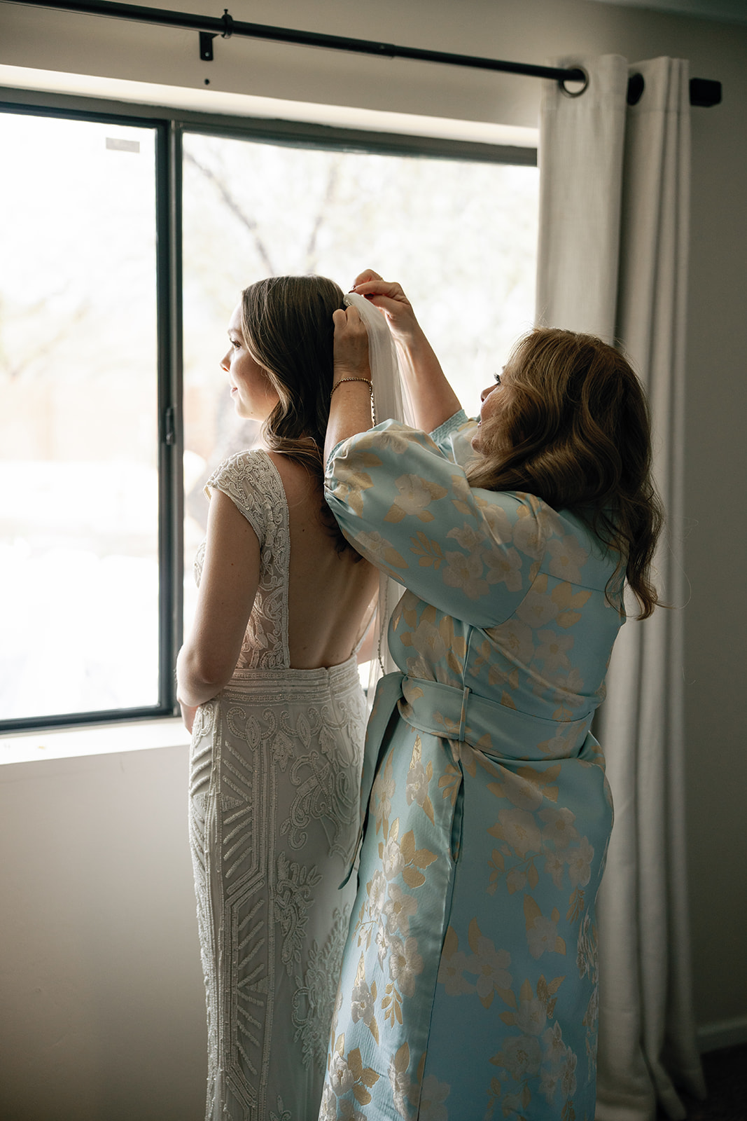 Mother of bride helping bride get ready for the non-traditional wedding