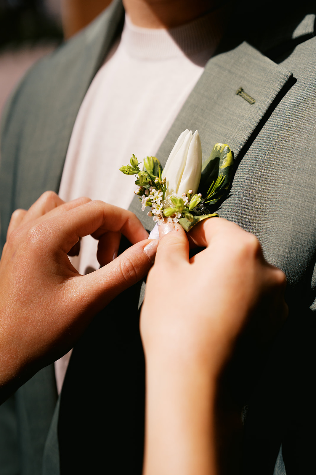 Hands pinning boutonniere