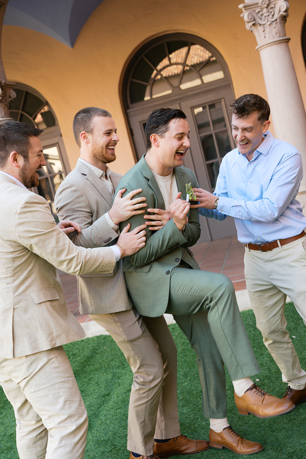 Friends celebrating groom playfully outdoors