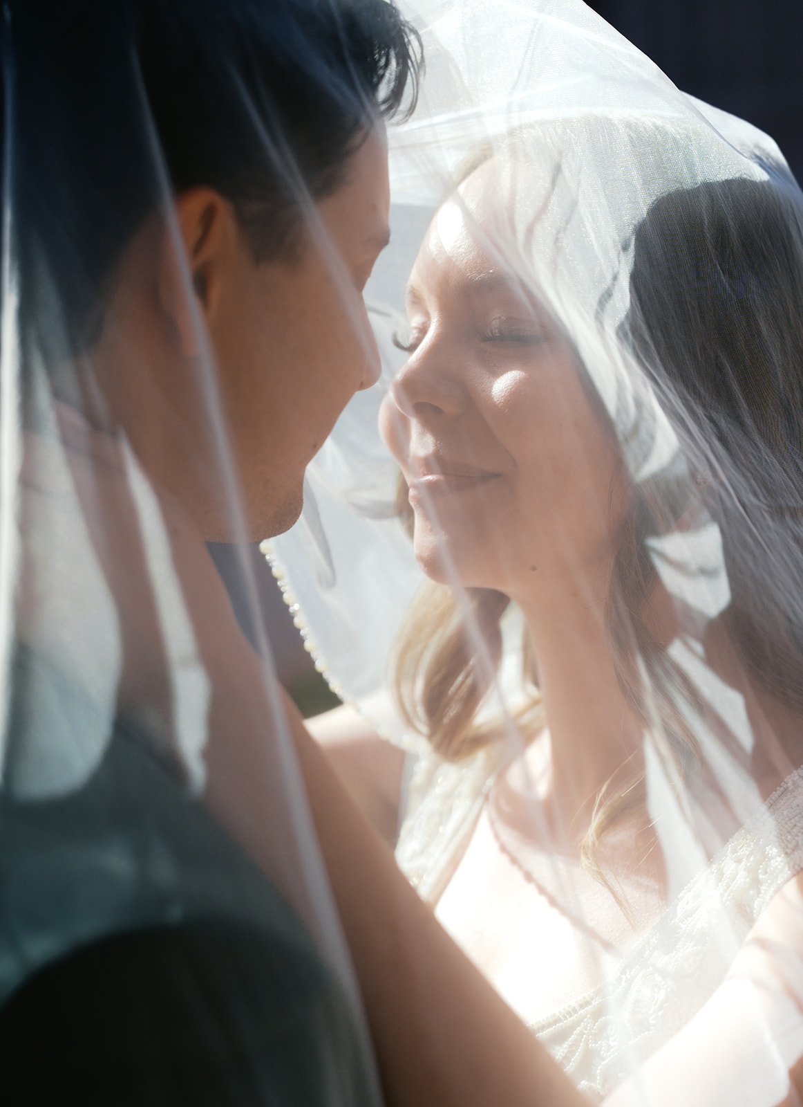 Bride smiling with partner in soft light