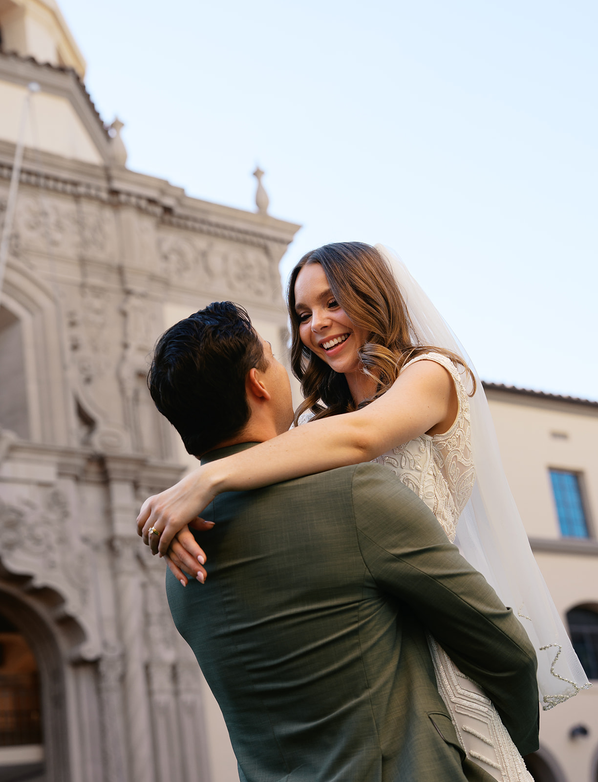 Couple embracing outside historic building after their non-traditional wedding ceremony