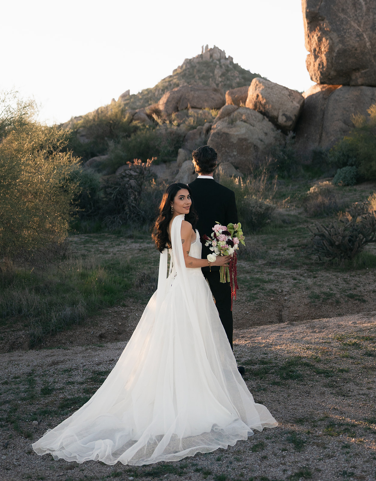 Couple embracing in desert after their non-traditional wedding