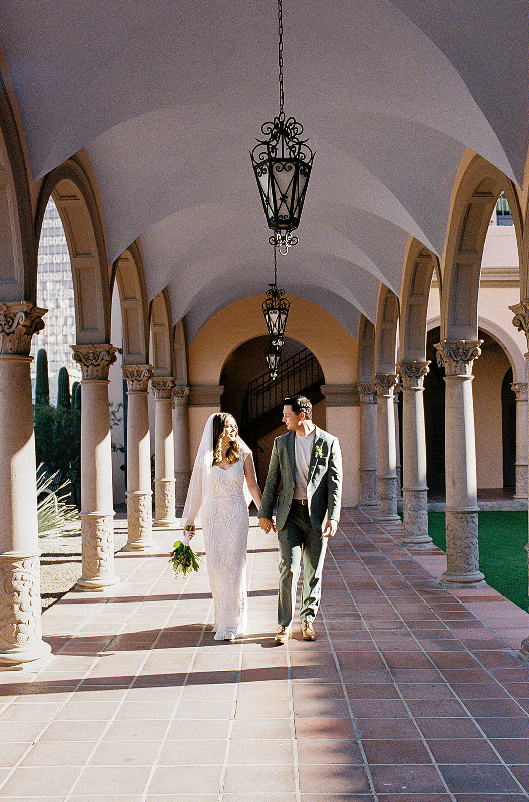 Couple walking together under repeating archways outdoors