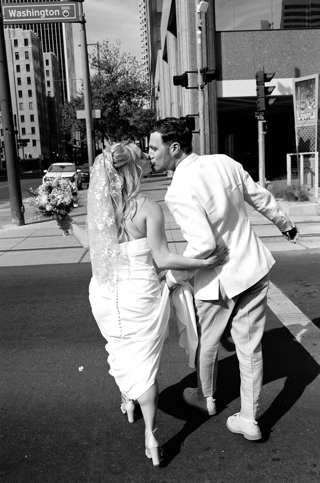 Newlyweds walking hand-in-hand across city street