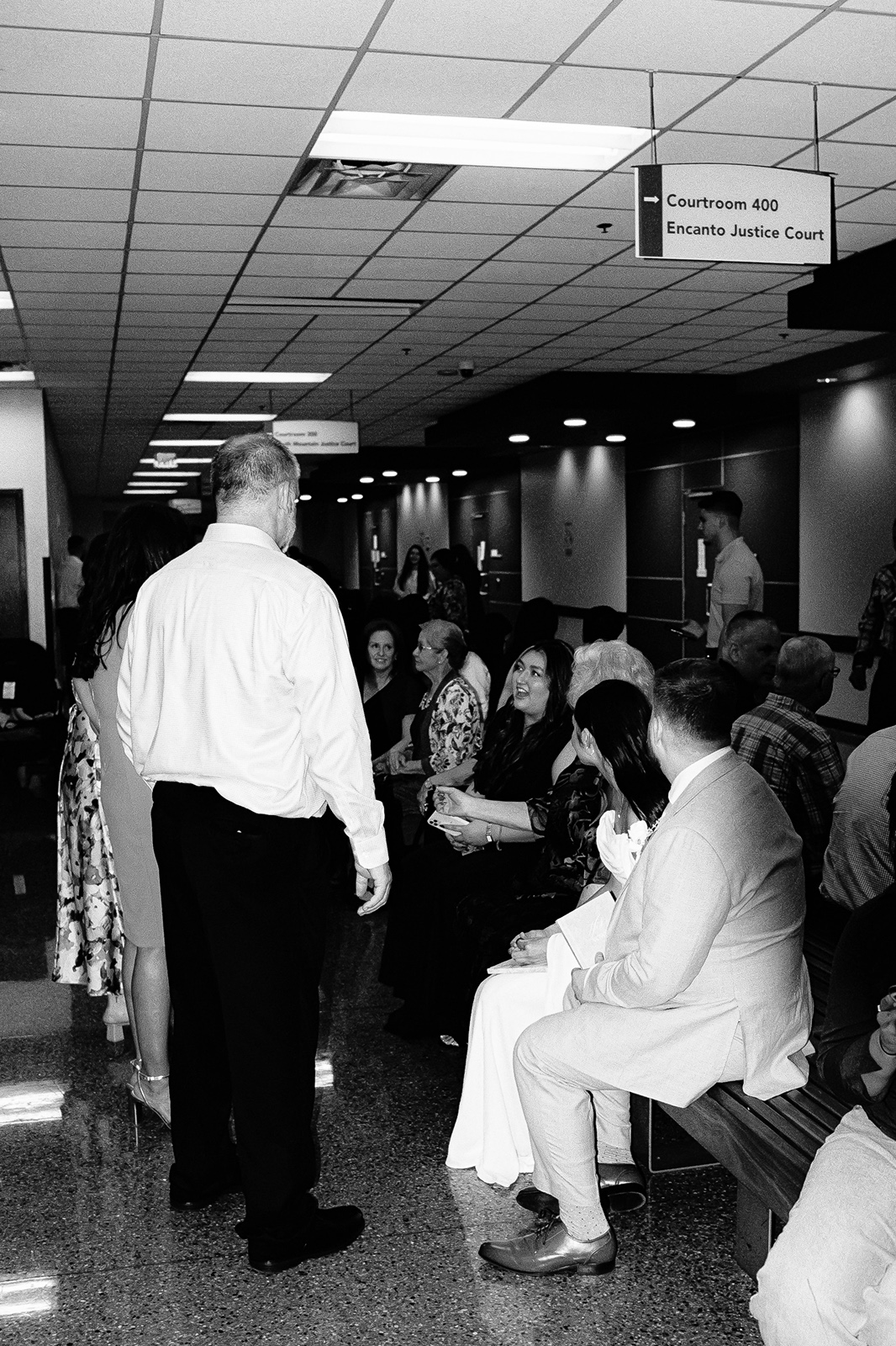 Bride and groom with guests inside courthouse hallway