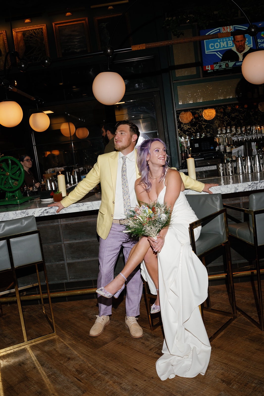 Bride and groom posing together at bar