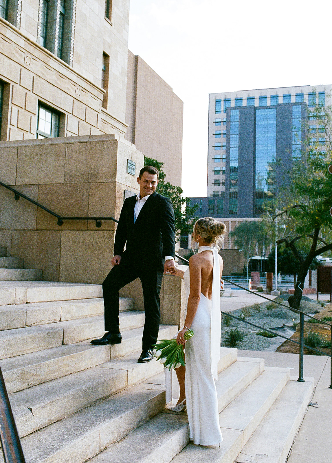 Bride approaching groom on courthouse steps outdoors