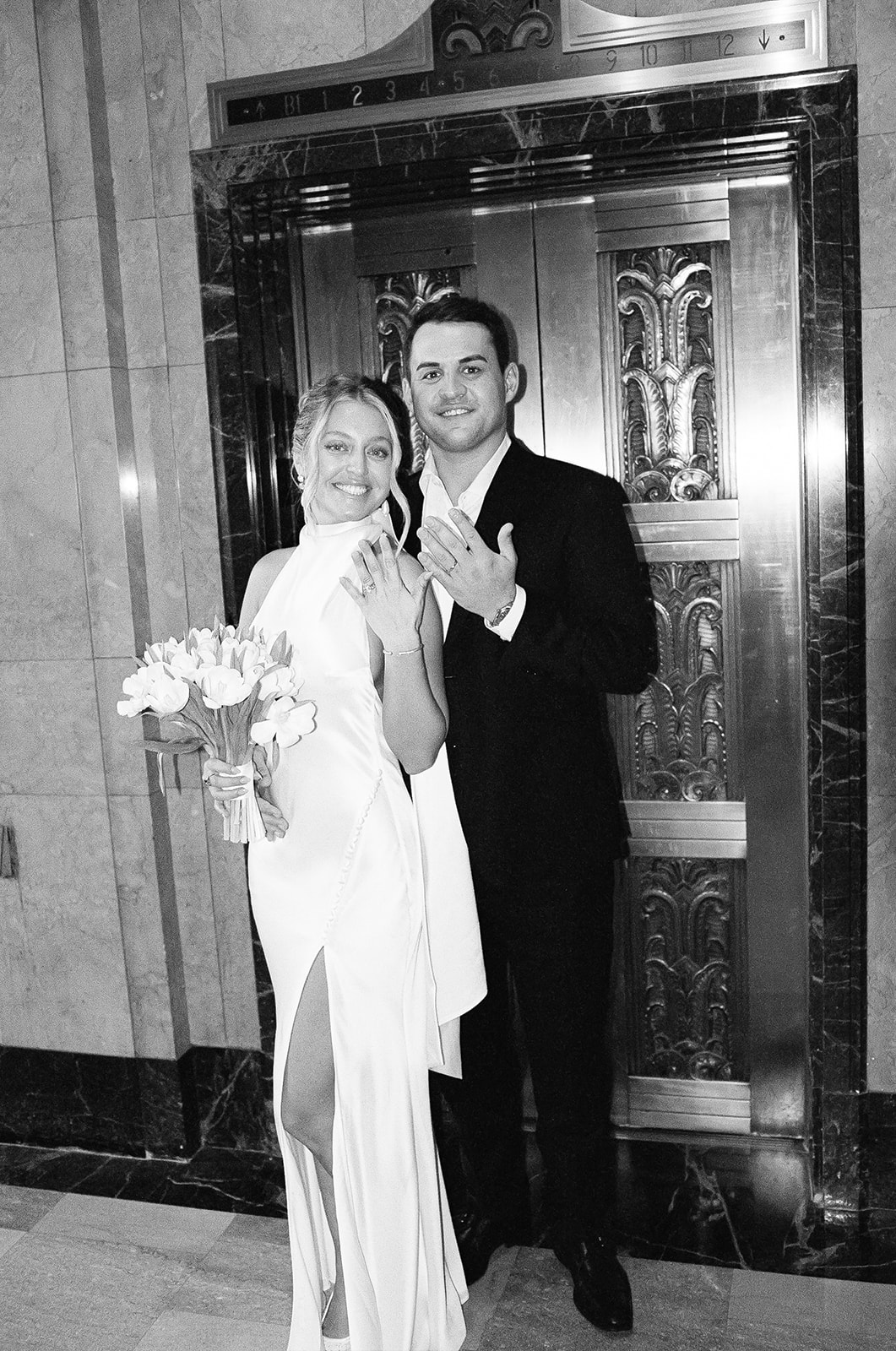 Couple smiling and holding up hands, black-and-white portrait