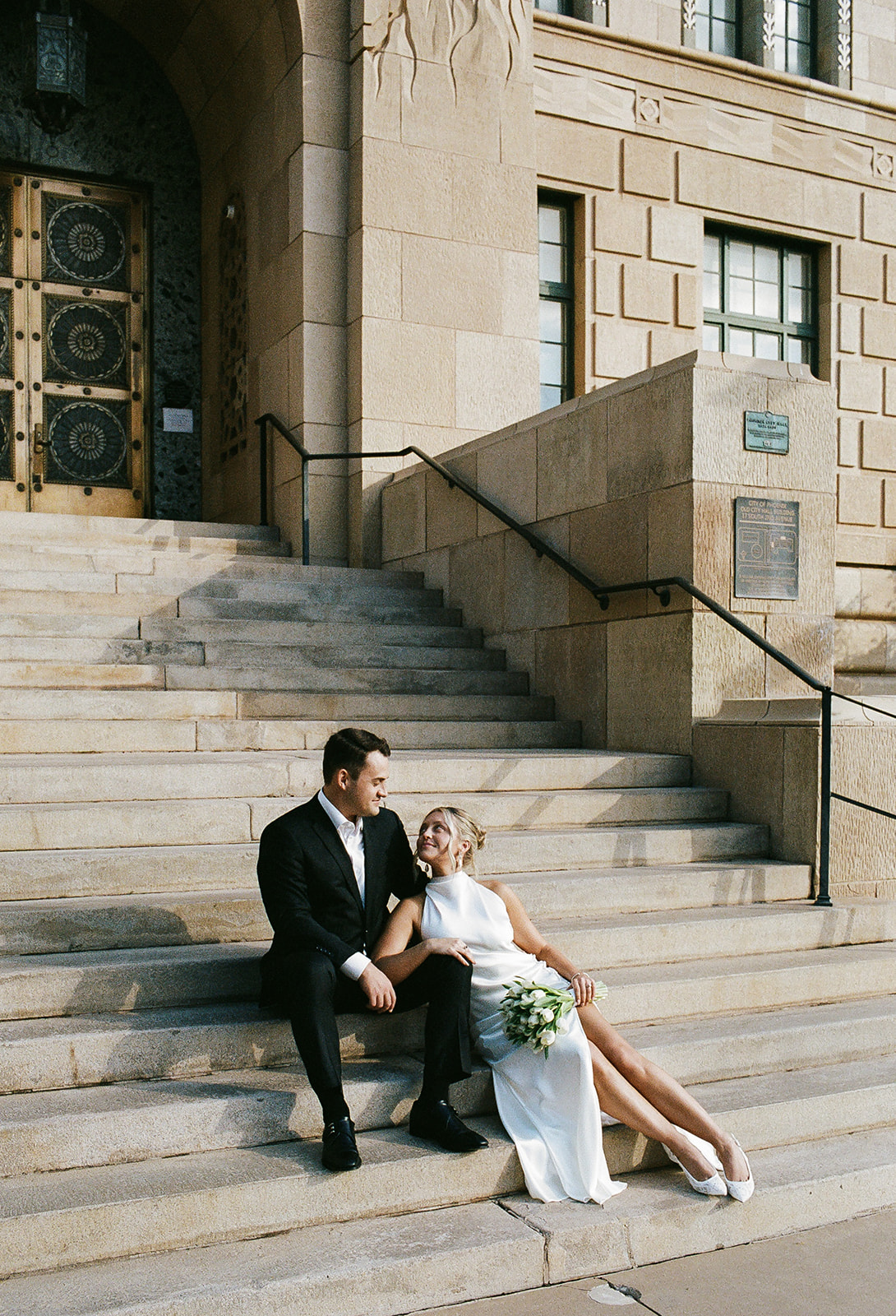 Couple sitting together on courthouse steps, relaxed