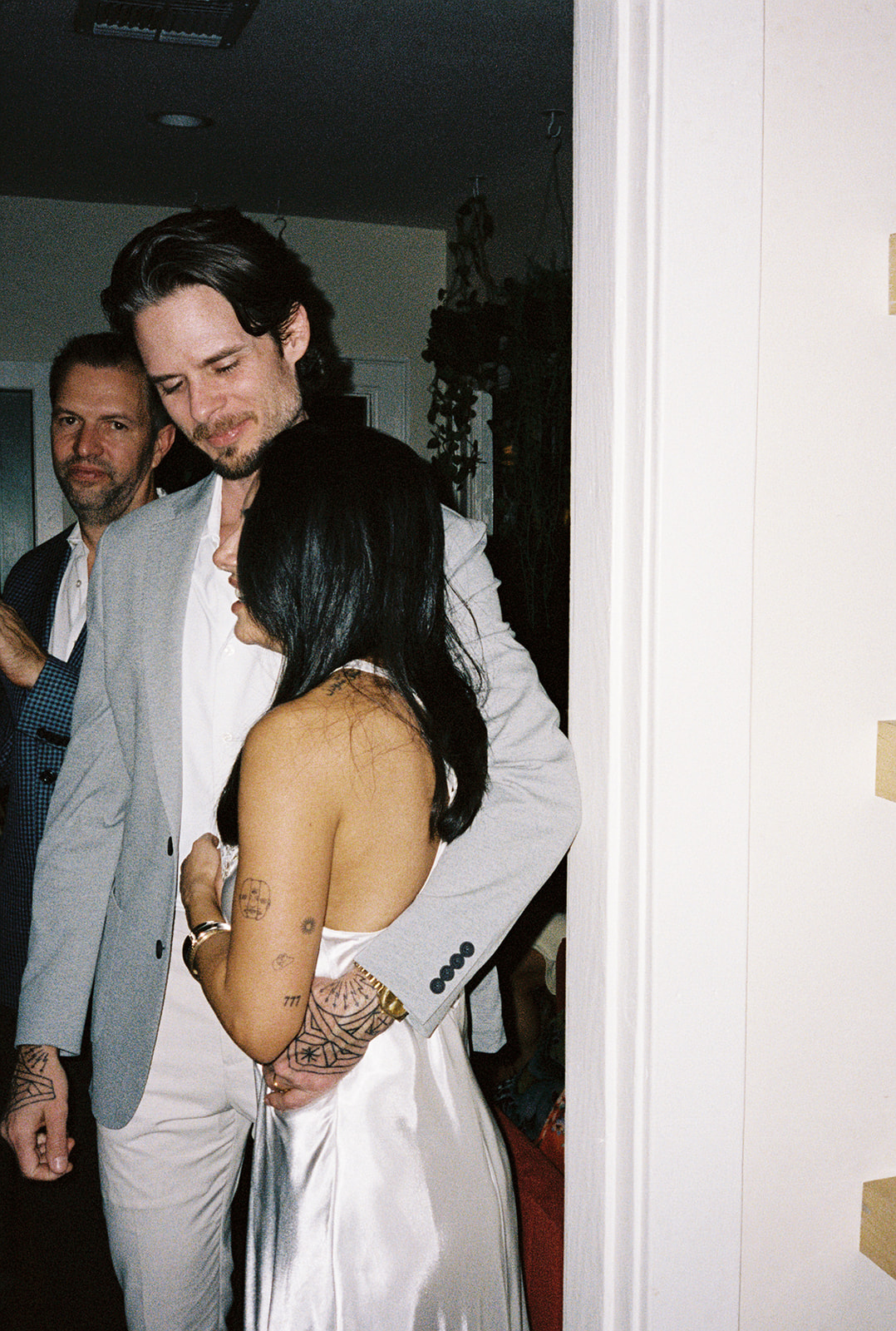Couple embracing in doorway, intimate candid moment