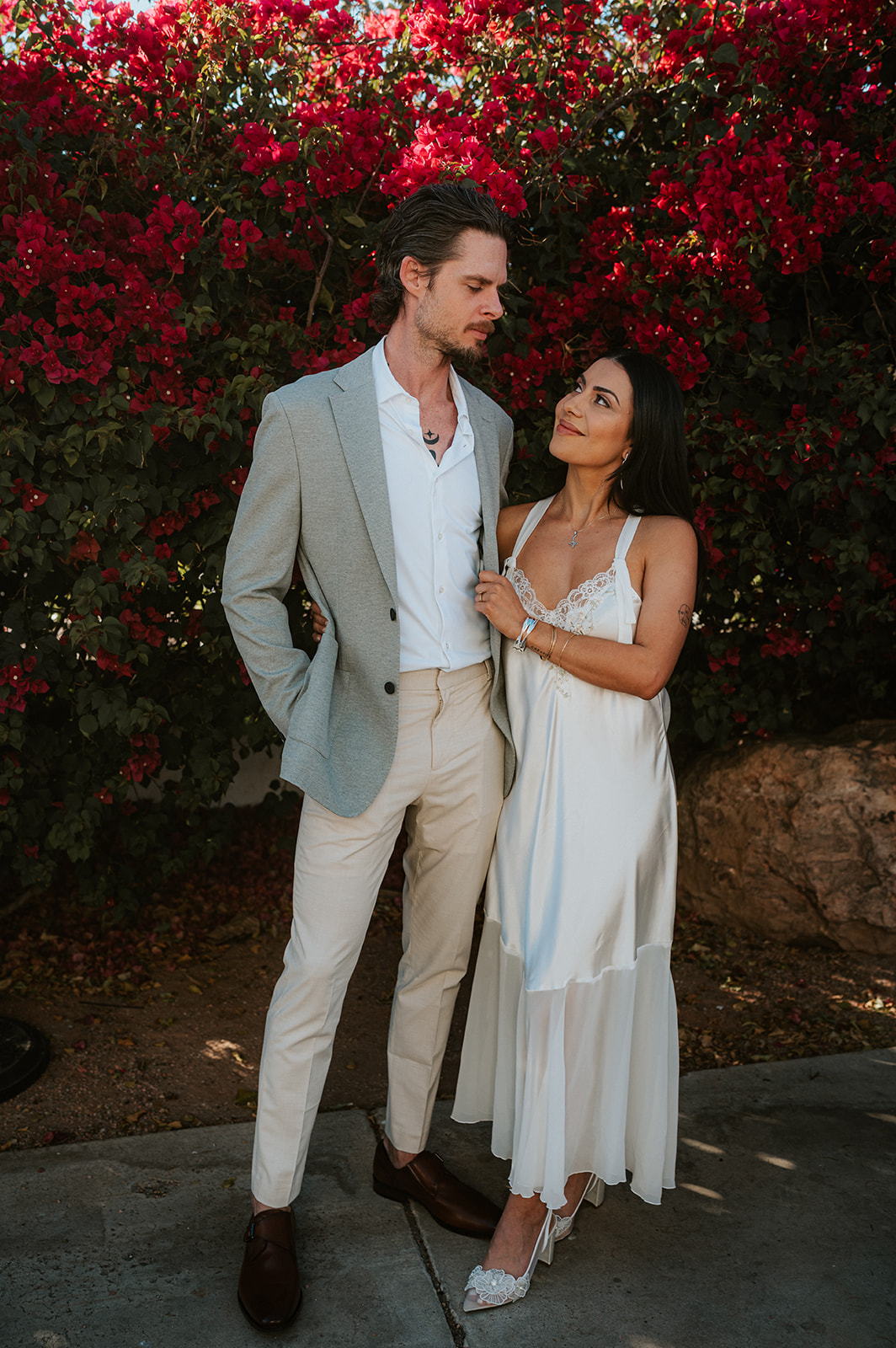 Phoenix courthouse wedding couple posing in front of red flowers