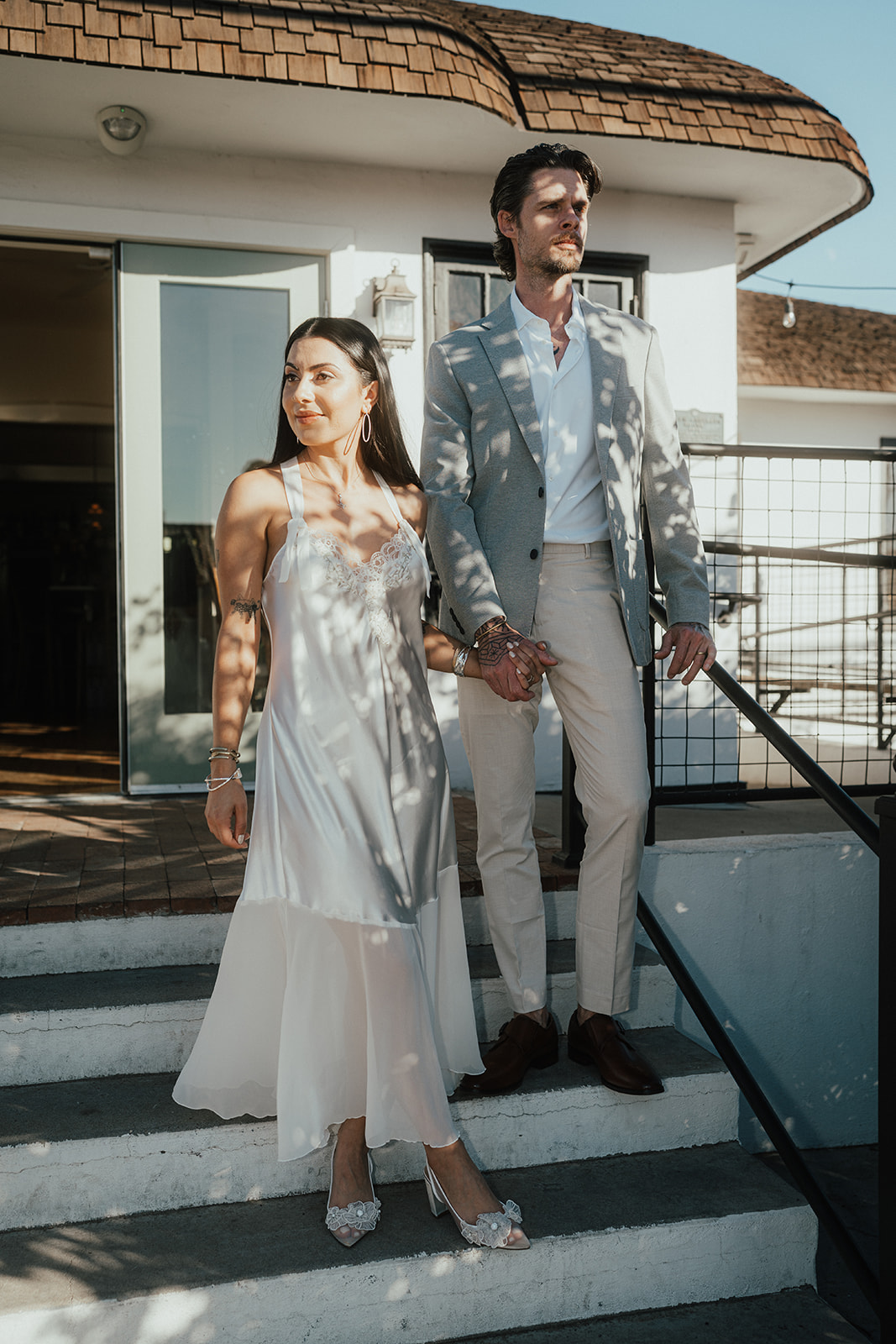 Couple standing together outdoors, dressed in wedding attire