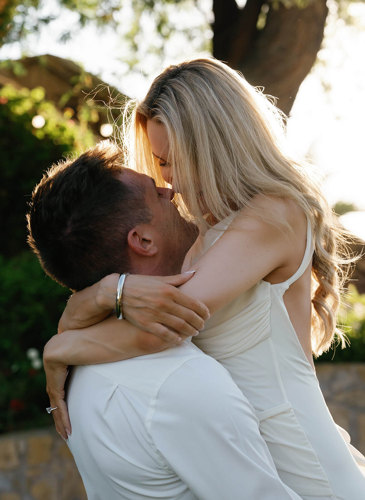 Close-up of couple about to kiss during engagement photos at Wrigley Mansion wedding venue with golden hour backlighting