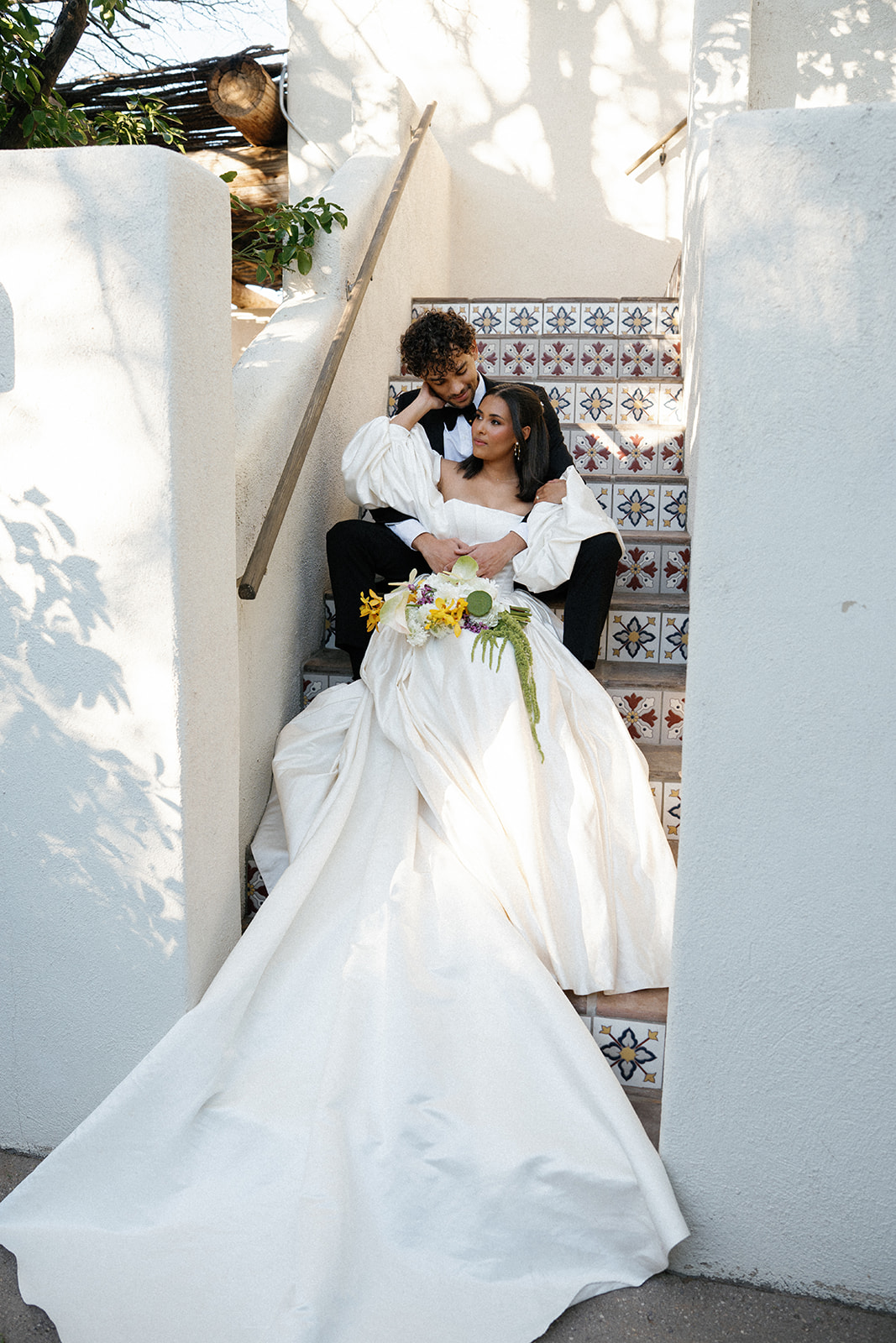 Bride and groom embrace on stairs at Joshua Tree House Tucson wedding