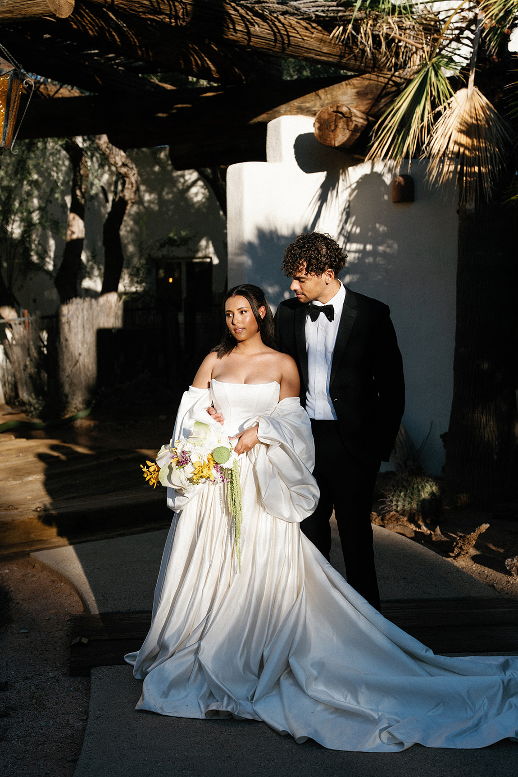 Couple walks through courtyard at Joshua Tree House Tucson wedding