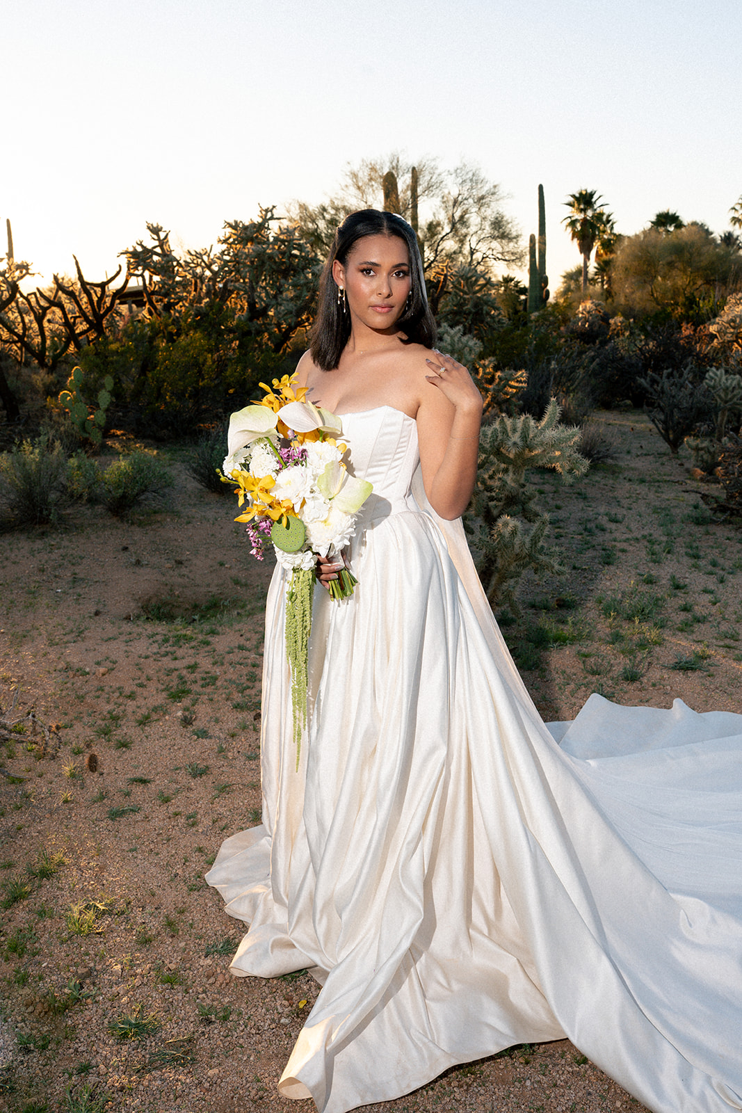 Bride holds bouquet in flowing dress during Joshua Tree House Tucson wedding