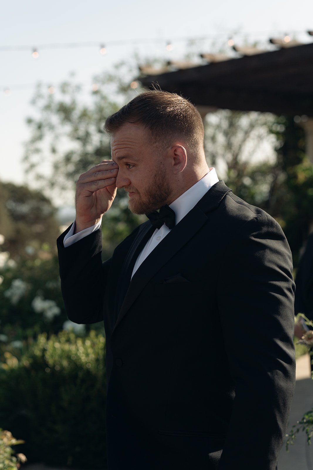 Emotional groom wiping away tears at the altar during an outdoor ceremony at Villa San Juliette
