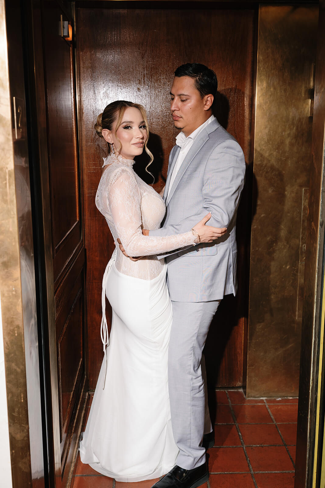 Bride and groom standing closely together inside a vintage elevator at the Wrigley Mansion in Phoenix, Arizona, creating an intimate wedding portrait.