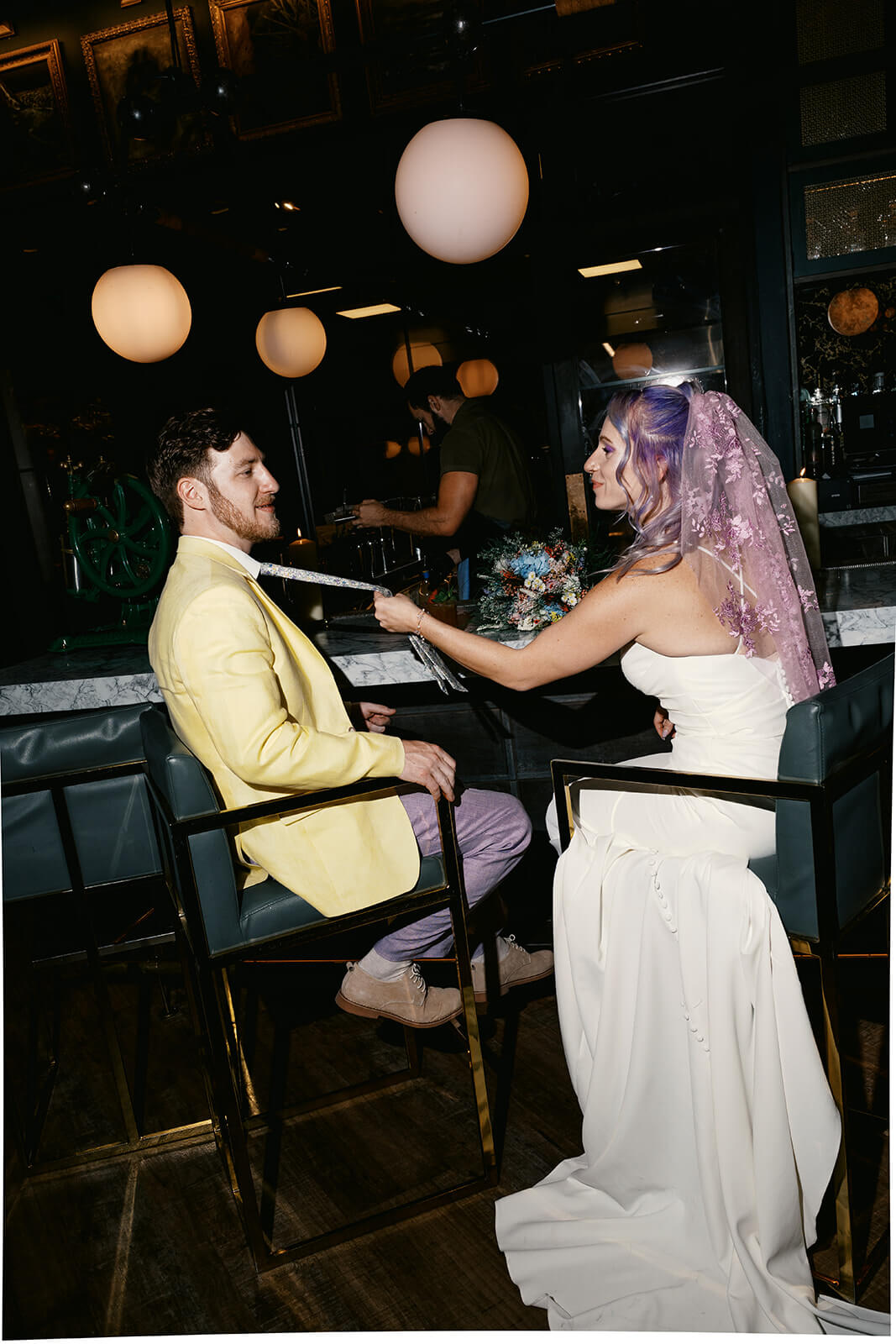 Bride playfully feeding groom cake during a fun and unconventional micro wedding reception