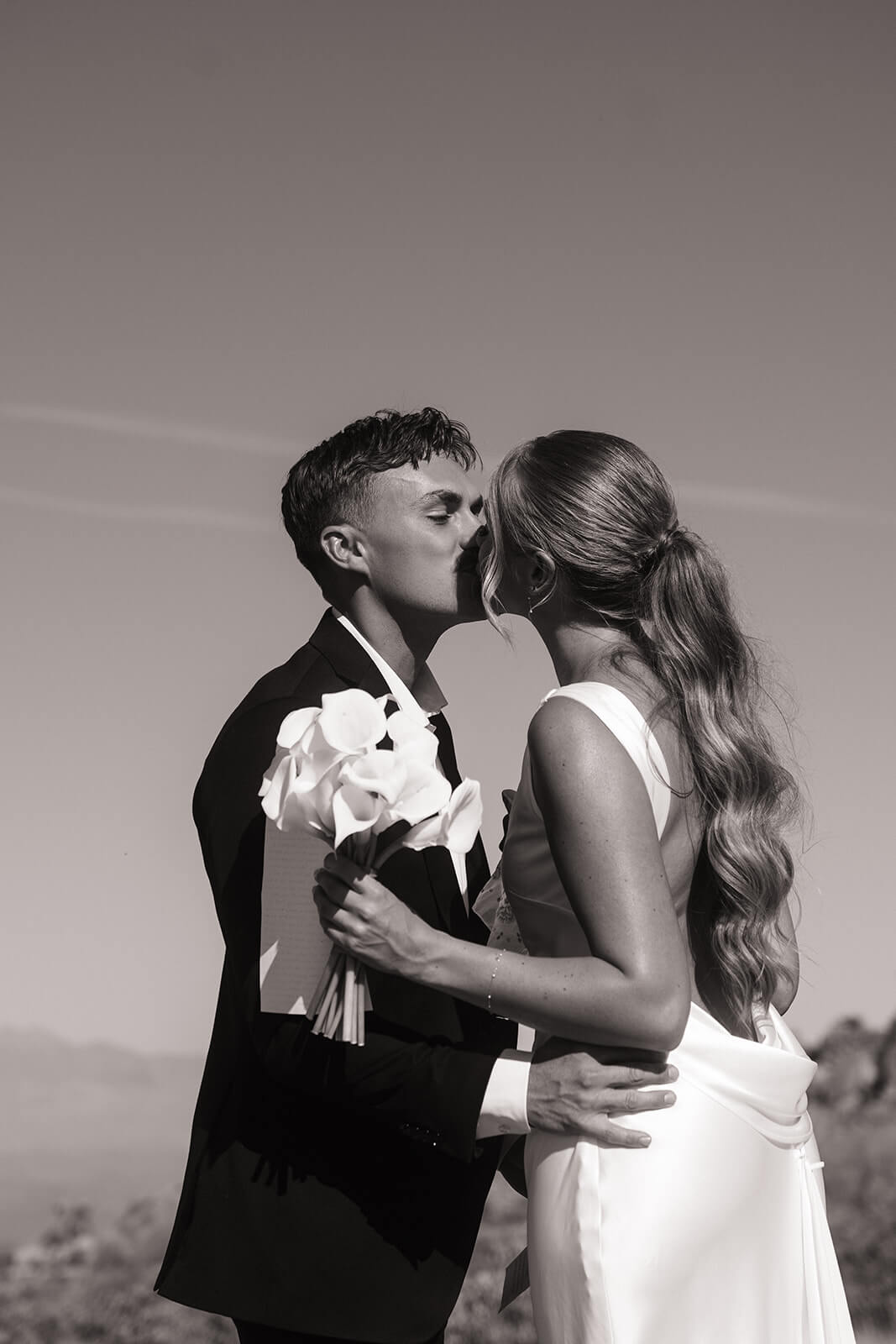 Black and white portrait of a couple kissing during their intimate desert elopement