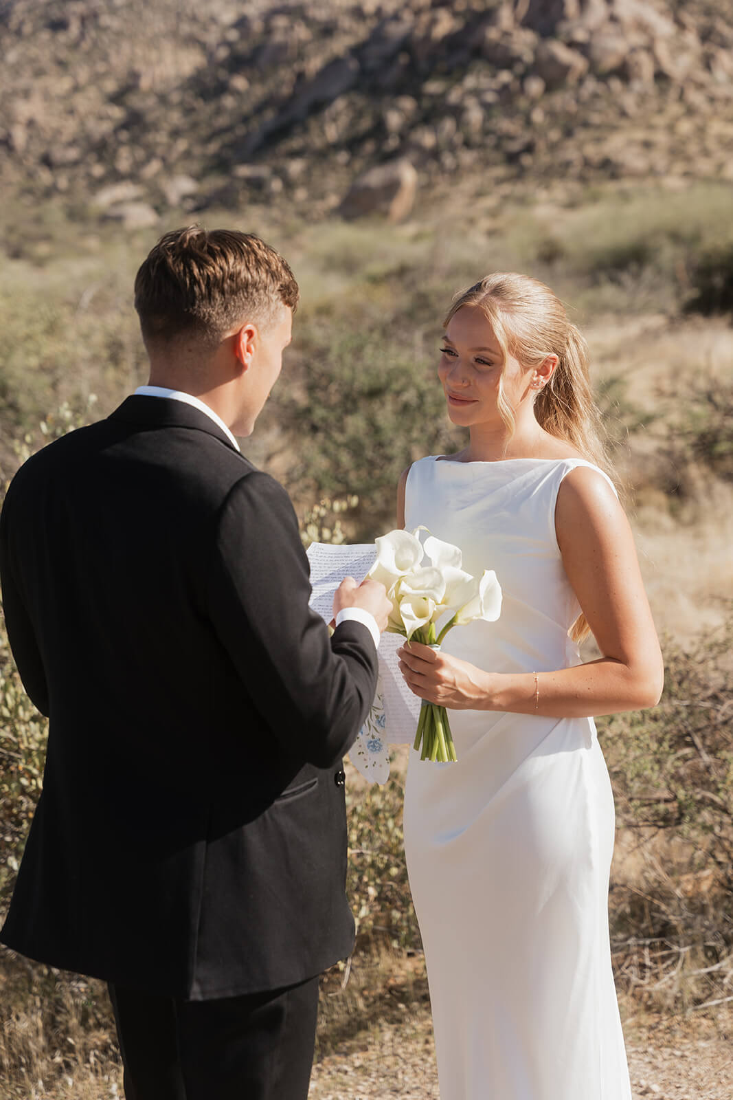 Couple exchanging private vows during a quiet desert elopement ceremony surrounded by mountains