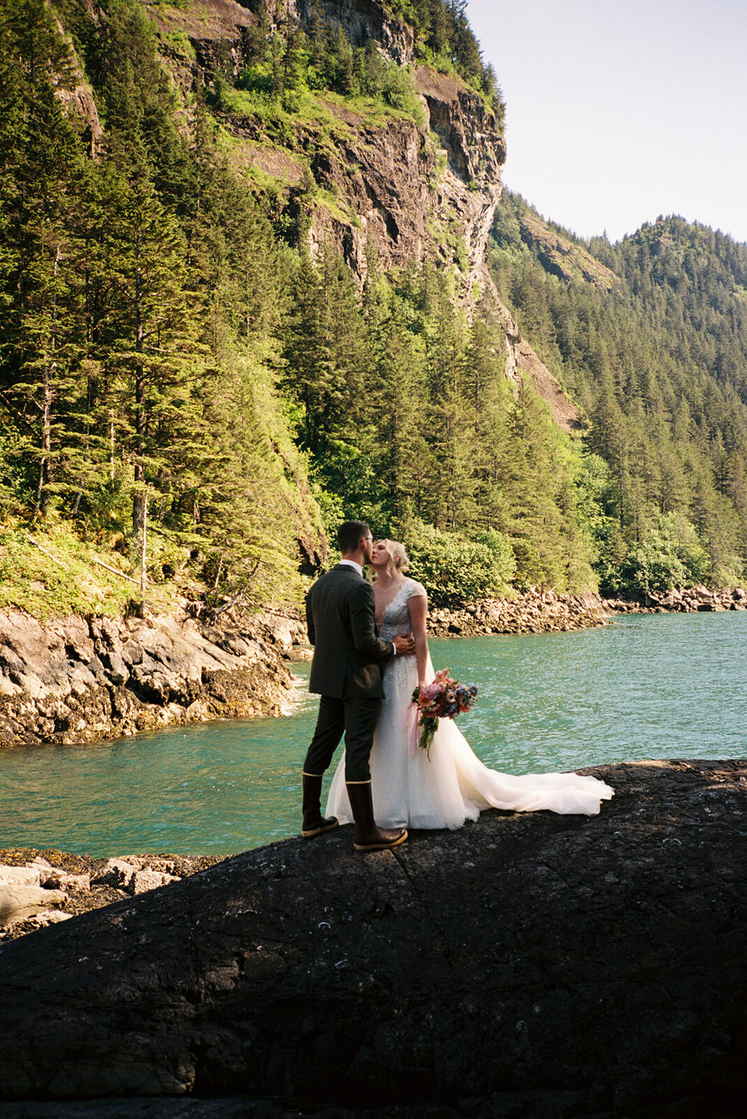 Couple standing together on coastal rocks during an adventurous micro wedding in the Pacific Northwest