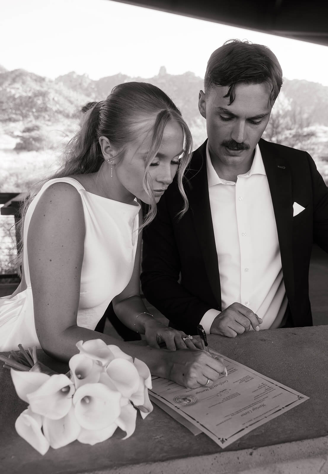 Couple signing their marriage license during an intimate desert elopement ceremony