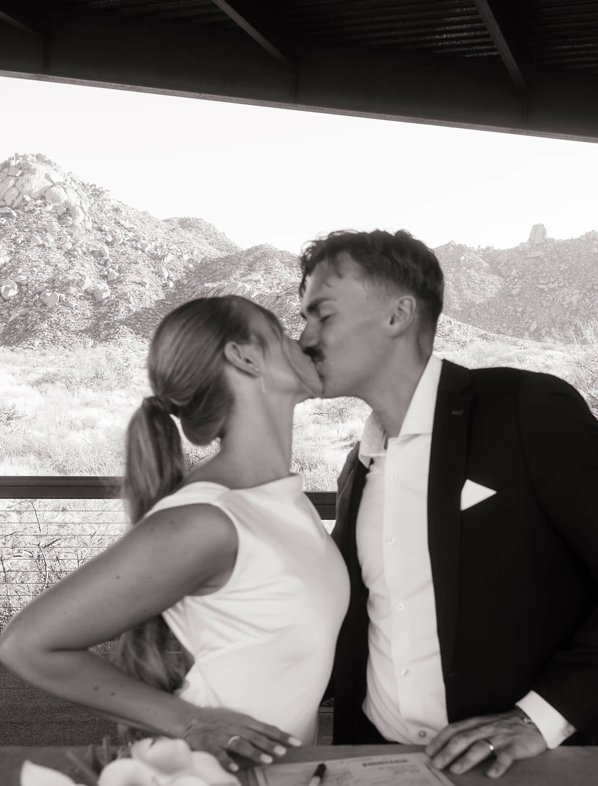Bride and groom kissing after signing their marriage license during a modern elopement celebration