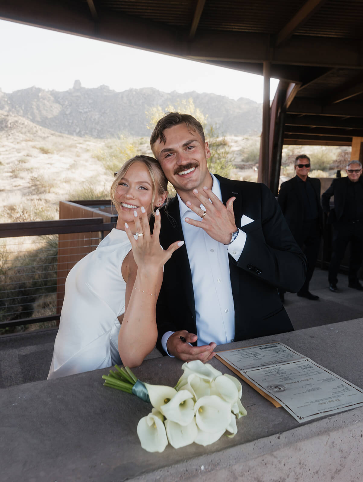 Newly married couple showing off their wedding rings after their micro wedding ceremony in the desert