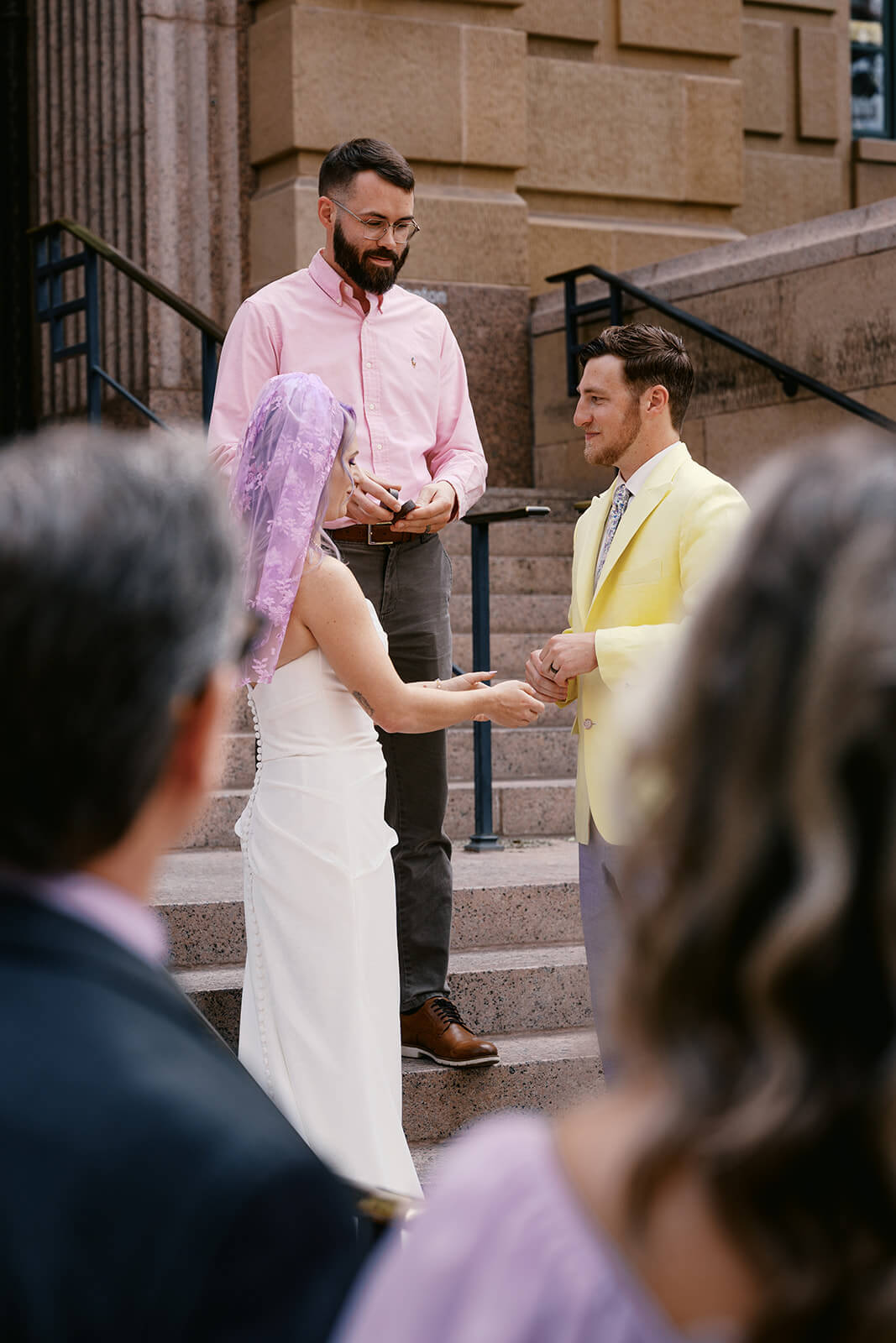 Guests watching a couple exchange vows during a stylish courthouse elopement ceremony