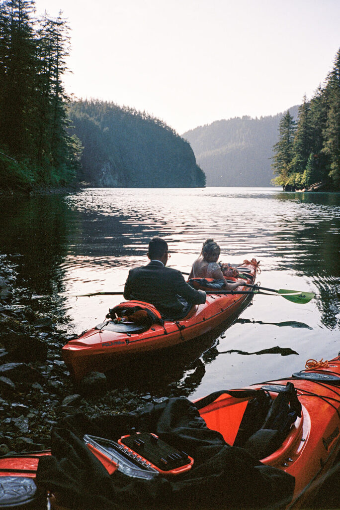 Couple kayaking together after their intimate lakeside elopement in the mountains