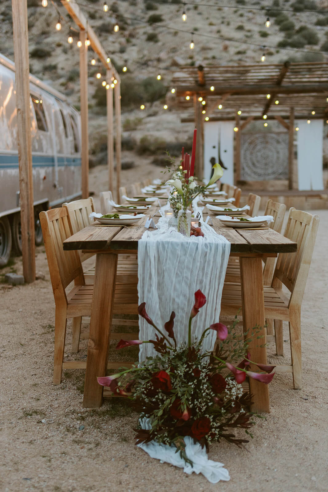 Long reception table setup for an intimate desert micro wedding with warm string lights and natural details