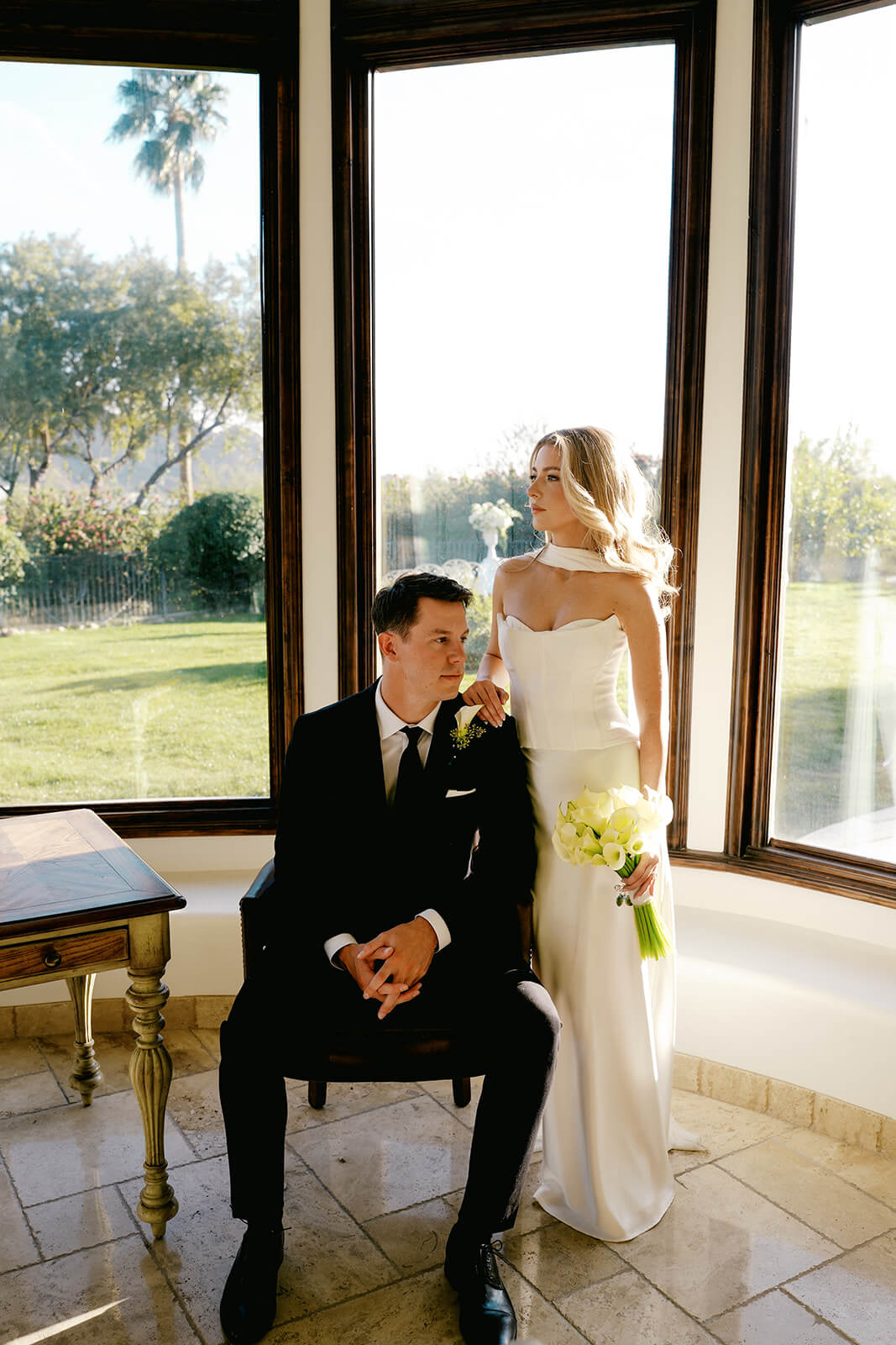 Elegant couple portraits inside a sunlit estate during a luxury micro wedding with modern bridal fashion