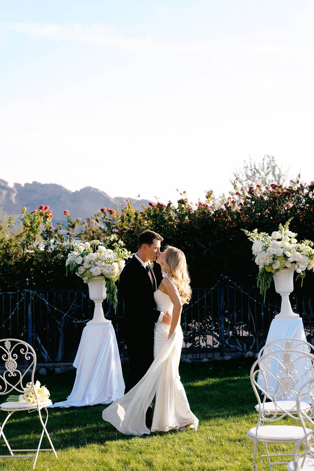Newly married couple embracing during an outdoor garden micro wedding ceremony with mountain views in the background