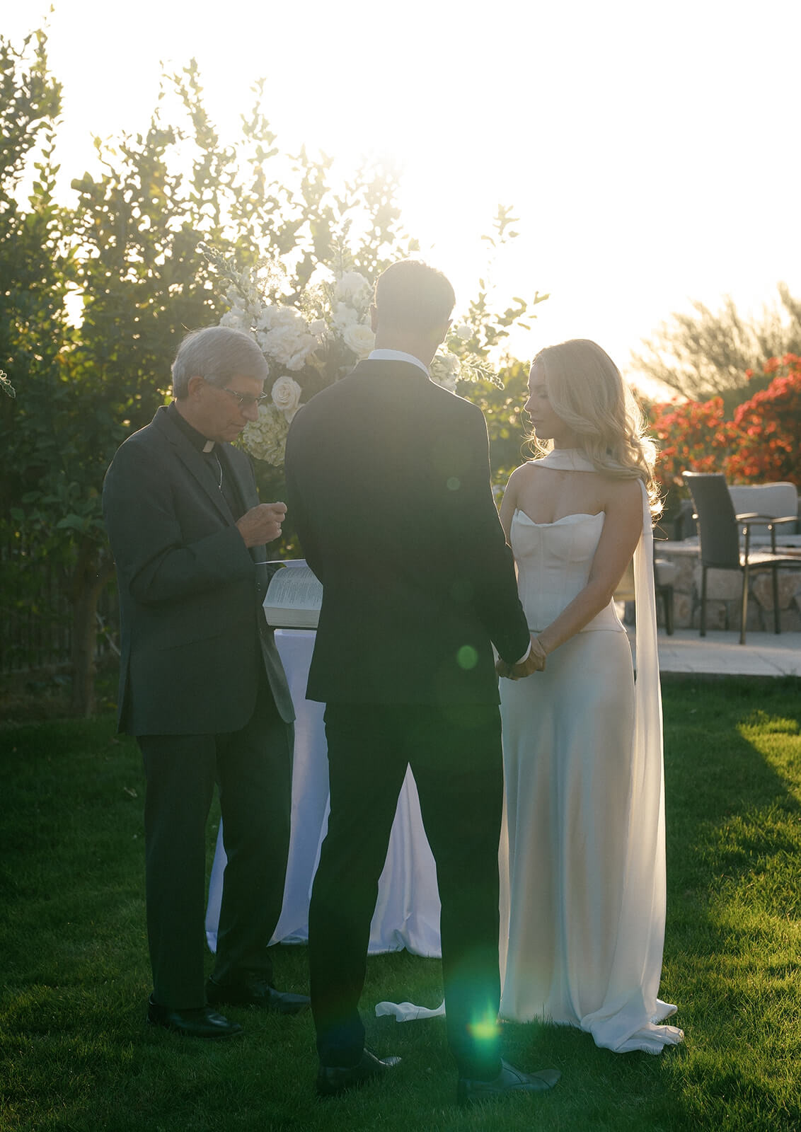 Couple exchanging vows during a golden hour garden elopement ceremony with warm sunset light