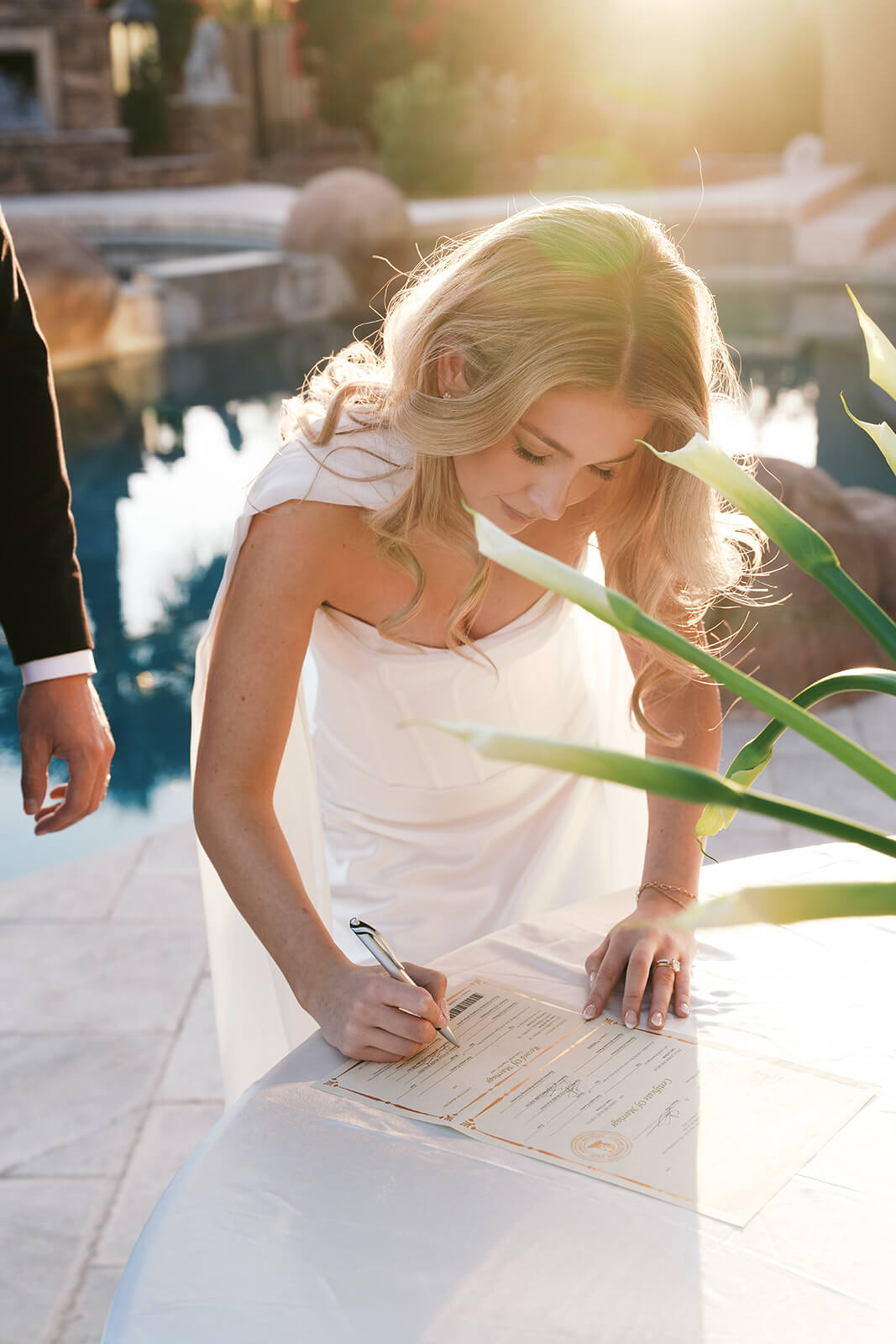 Bride signing marriage license during an intimate luxury backyard wedding reception