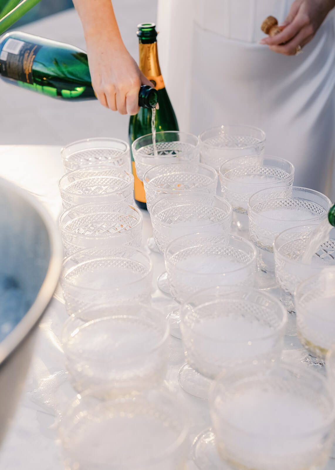 Champagne being poured into coupe glasses during a stylish micro wedding celebration