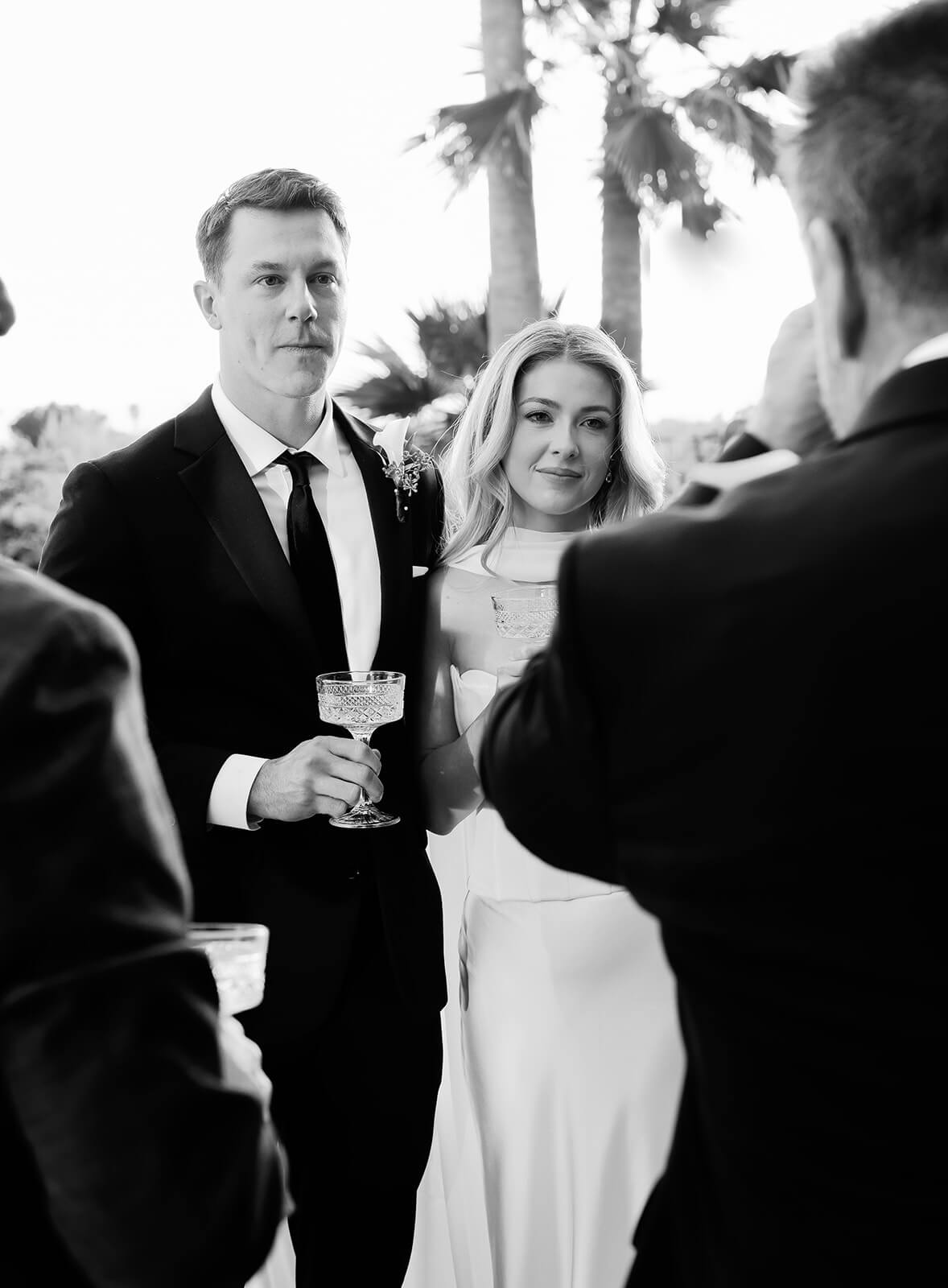 Couple listening to a wedding toast during an elegant outdoor wedding reception
