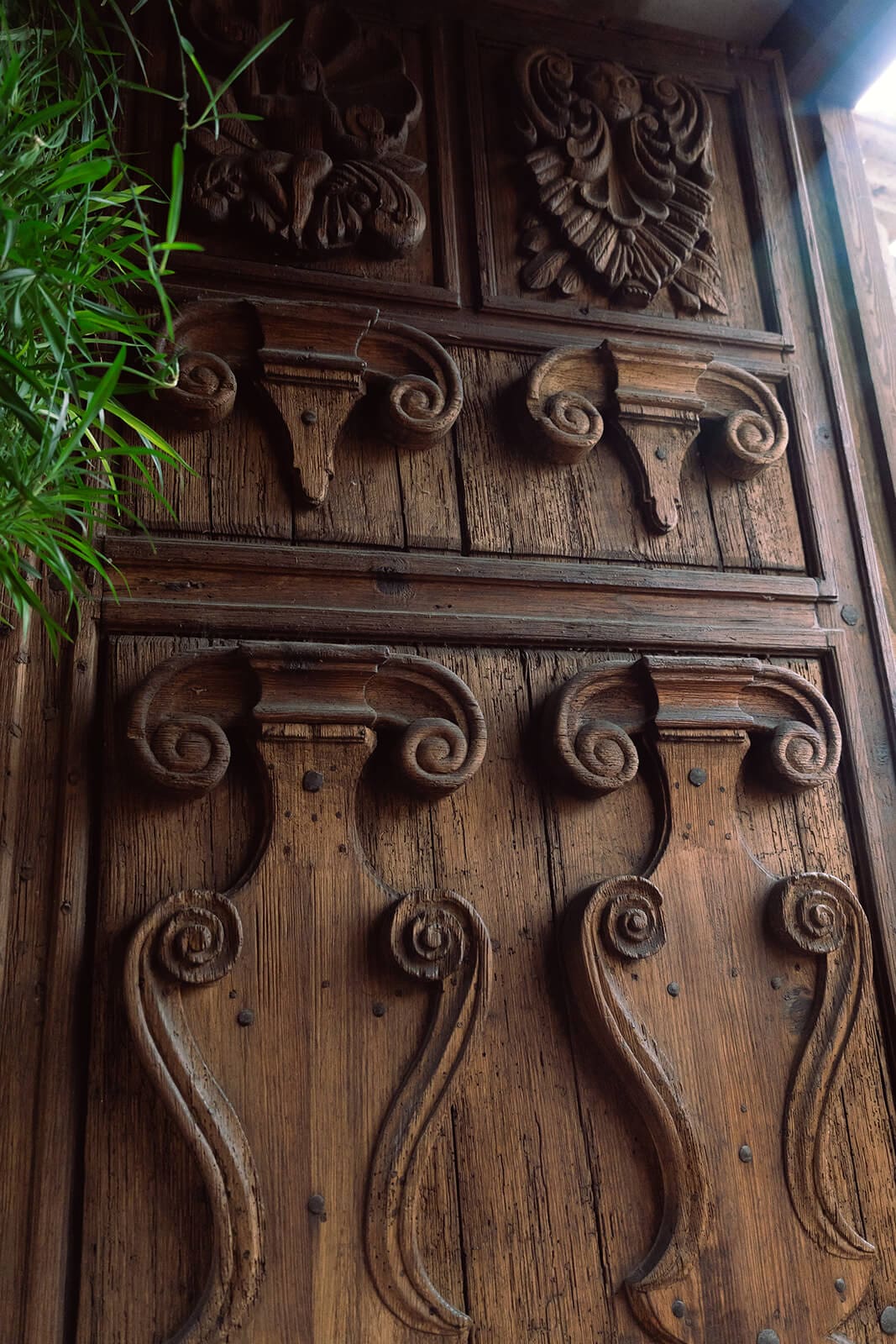 Close-up photo of a carved wooden door with ornate details at Tlaquepaque.